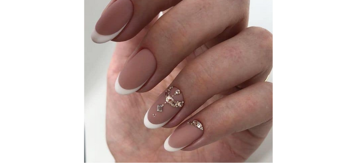 Ongles nudes courts avec détail français et bijou doré